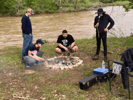 Luke and some coworkers around a campfire on an MMM work trip